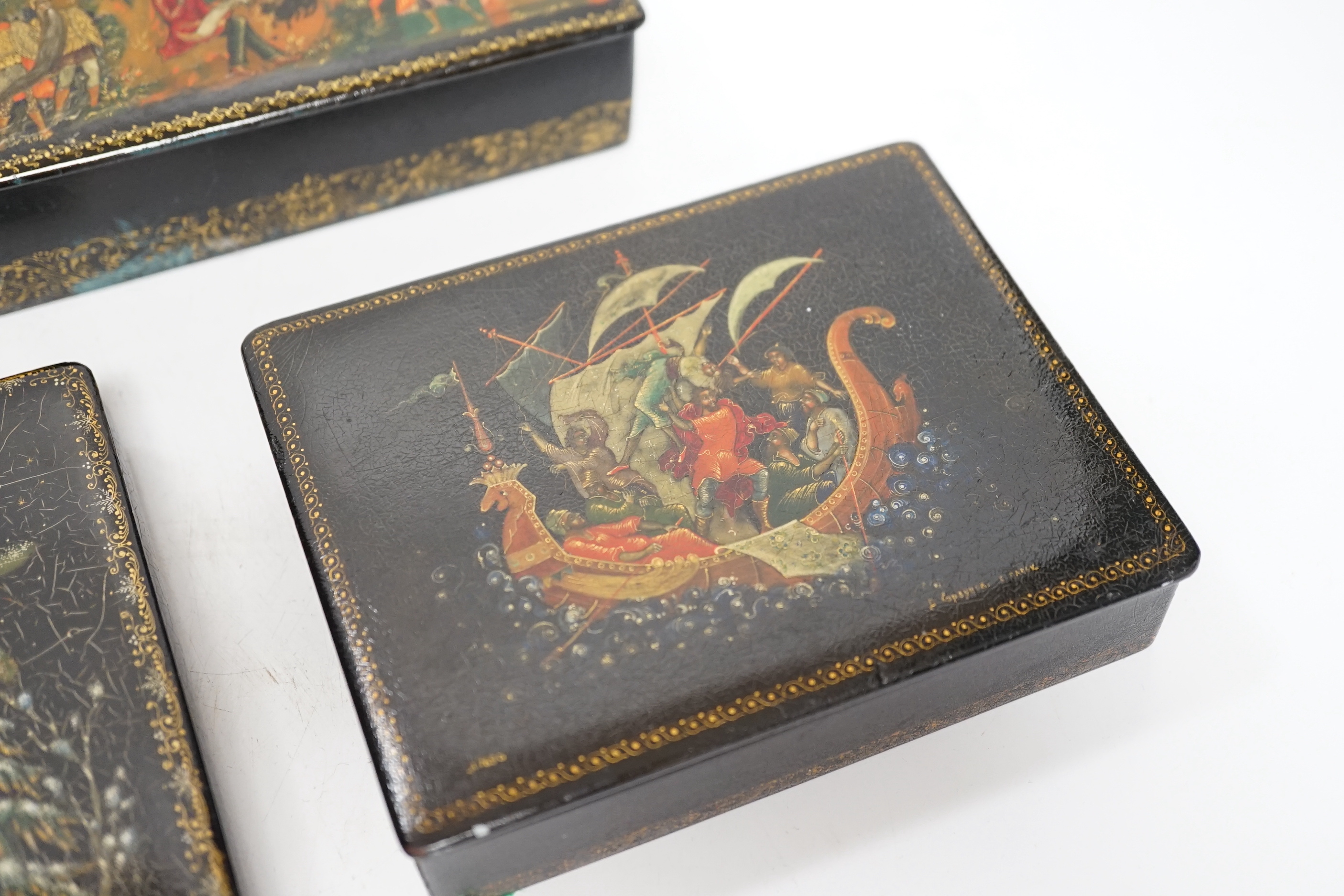 Five Russian Palekh lacquer table boxes, each painted with figures from legend, each signed by the artist, the largest 17 cm wide